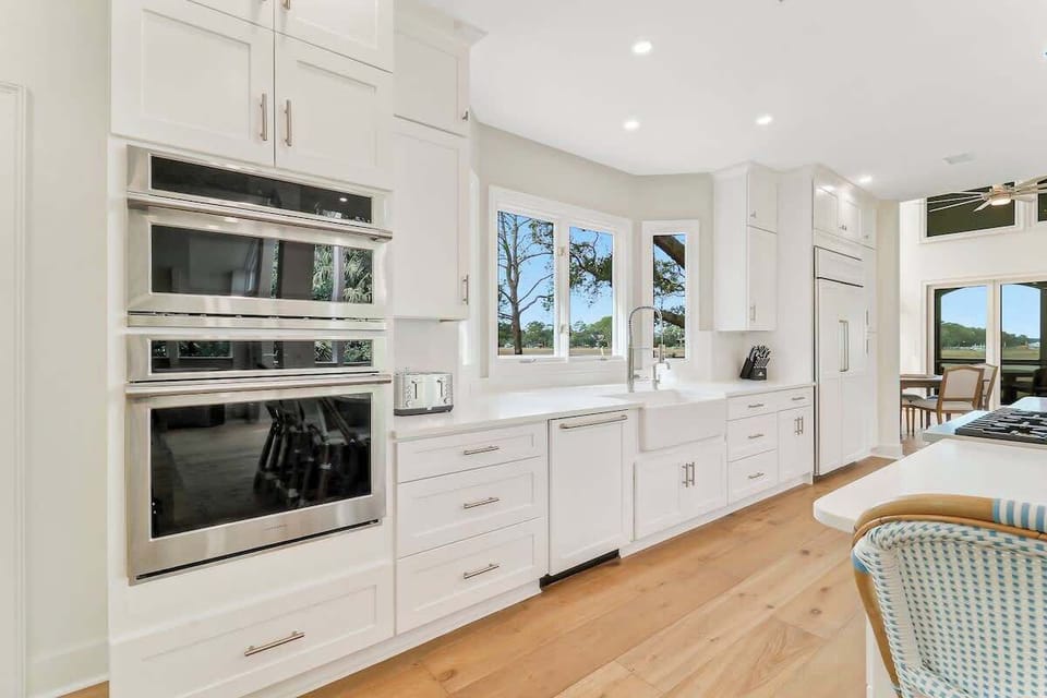 Cook with ease in your gourmet kitchen featuring premium appliances, abundant storage, and bright natural light streaming through garden windows.
