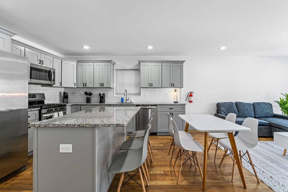 Fully equipped kitchen with island seating and dedicated dining table. Great for guests who plan to cook regularly. Ample counter space and cabinet storage make this functional for extended midterm use, not just weekend stays.