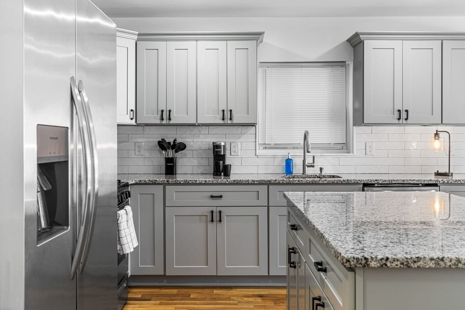 Modern kitchen with stainless steel appliances, granite countertops, and full-size refrigerator. Designed for real cooking, not just reheating. Ideal for traveling professionals staying 30+ days who want a home-style setup.