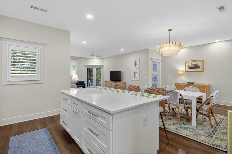 Your open-concept kitchen flows seamlessly into the dining area, perfect for gathering over home-cooked meals under the elegant chandelier.