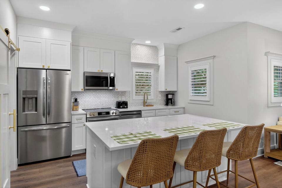 Your bright kitchen features modern appliances, spacious quartz counters, and a breakfast bar perfect for morning coffee and meal prep.