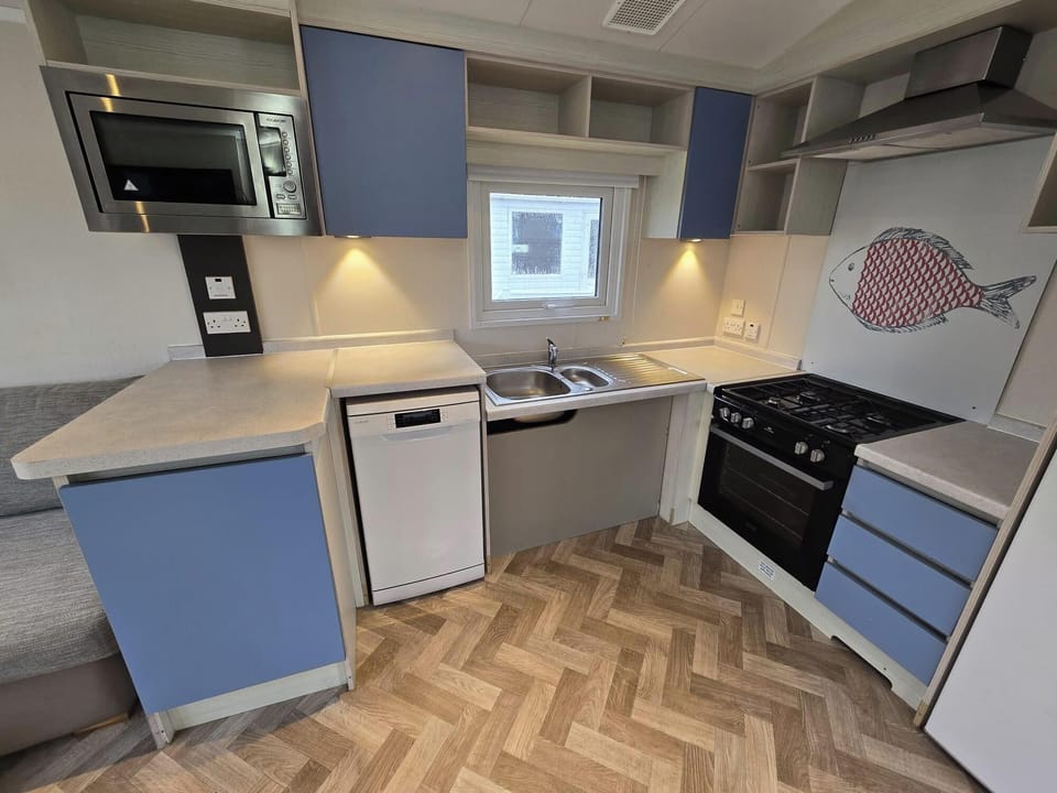 Large clear kitchen, low level hob, sink and food prep area.