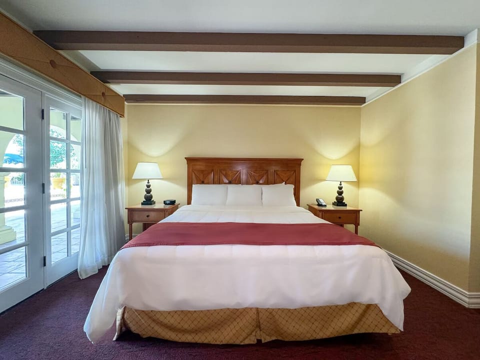 Unwind in crisp linens beneath warm, rustic ceiling beams.