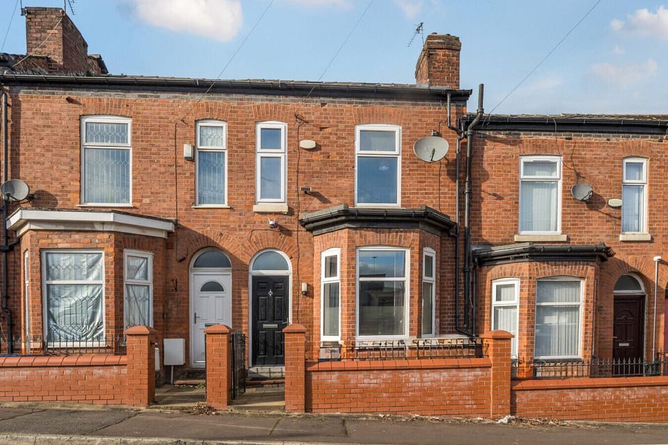 Red brick terraced street showing the exterior frontage of the property alongside neighbouring houses.