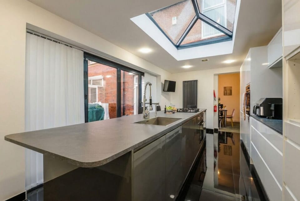 Kitchen island with a chef-grade sink tap and easy access to the garden and hot tub.