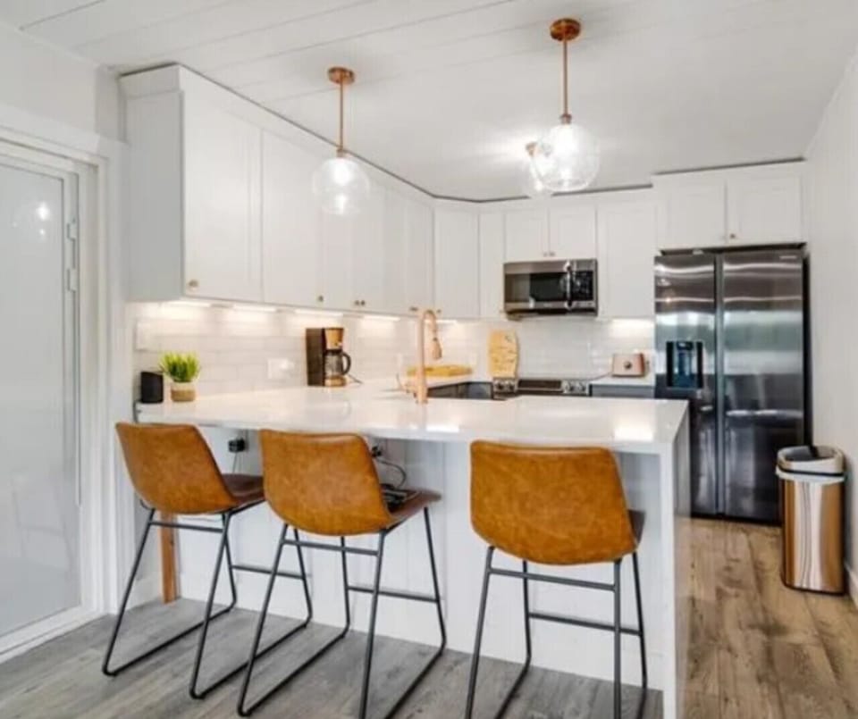 Gorgeous modern kitchen with quartz island, stainless steel appliances, and stylish pendant lighting!