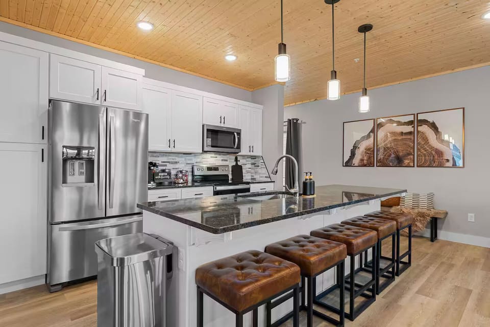 Kitchen: Gather around the stylish island with leather stools for meals.