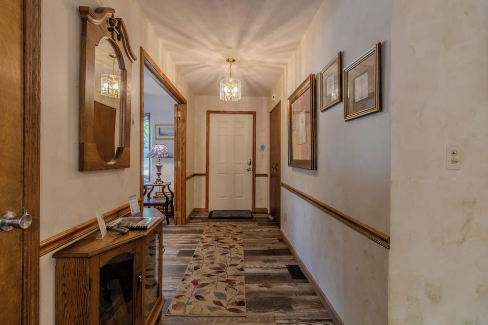 Entryway Hallway - The door pictured is the main entry door at the front of the house. The stairs to the basement are on the left and the hallway to bedrooms and bathrooms is to the right.