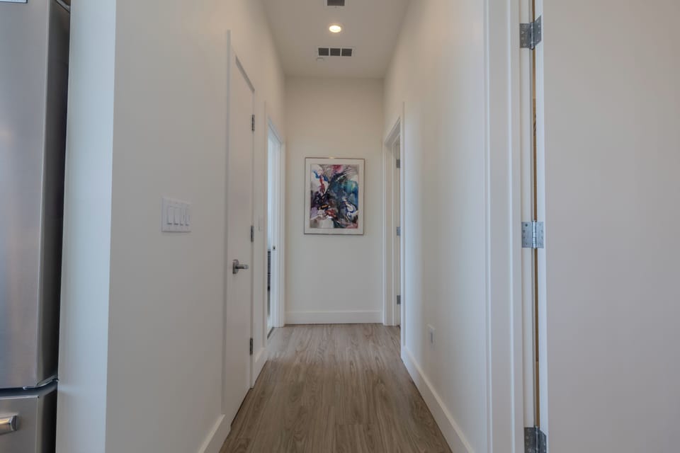 Lower Level - Hallway - Main bathroom is the first door on the right. One king room is the last door on the right, while the primary king suite is the last door on the left. The other door is a linen closet.