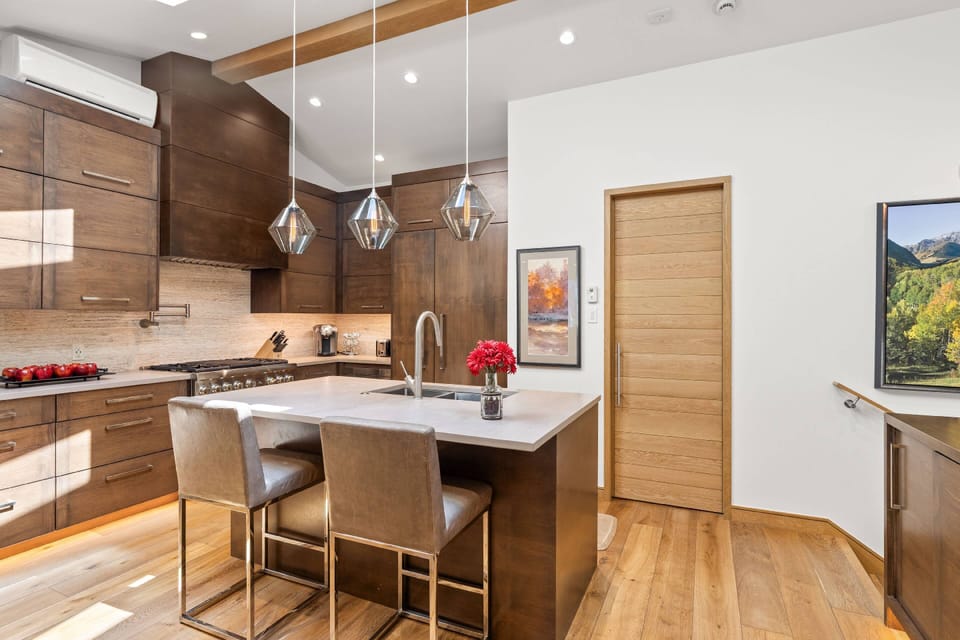 Rich walnut cabinetry, designer pendant lighting, and premium stainless appliances make this kitchen as functional as it is beautiful.