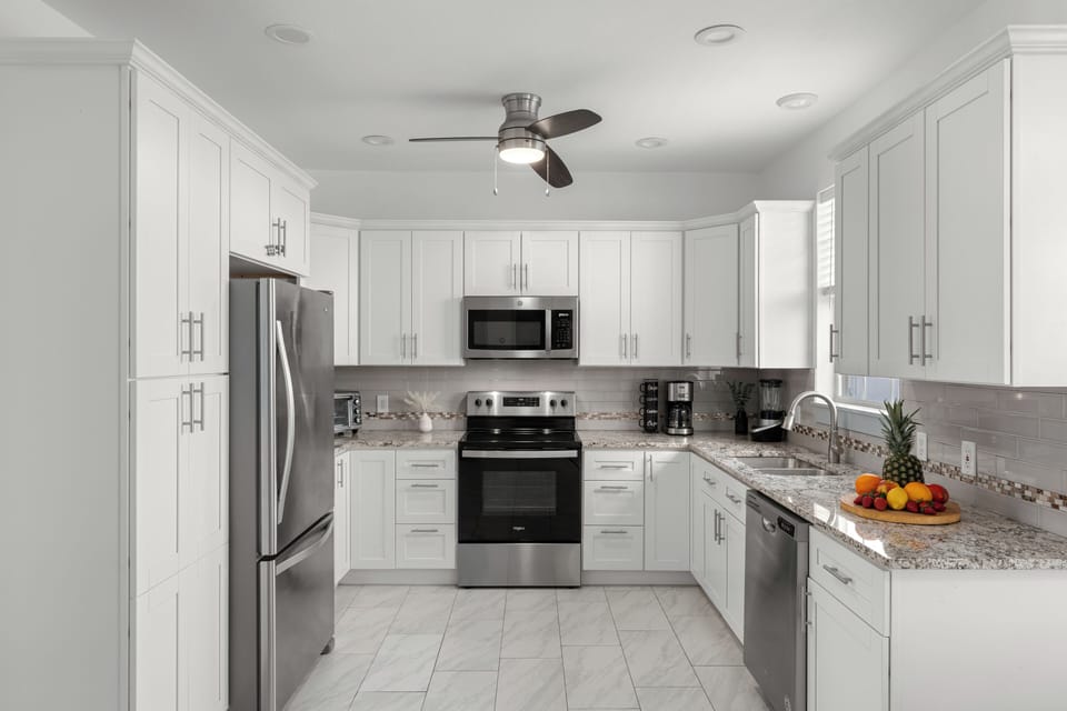 Sleek white cabinetry and a full stainless steel appliance suite.