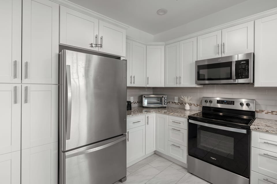 Chef’s kitchen. Close-up of the stainless steel refrigerator and ample cabinet storage.