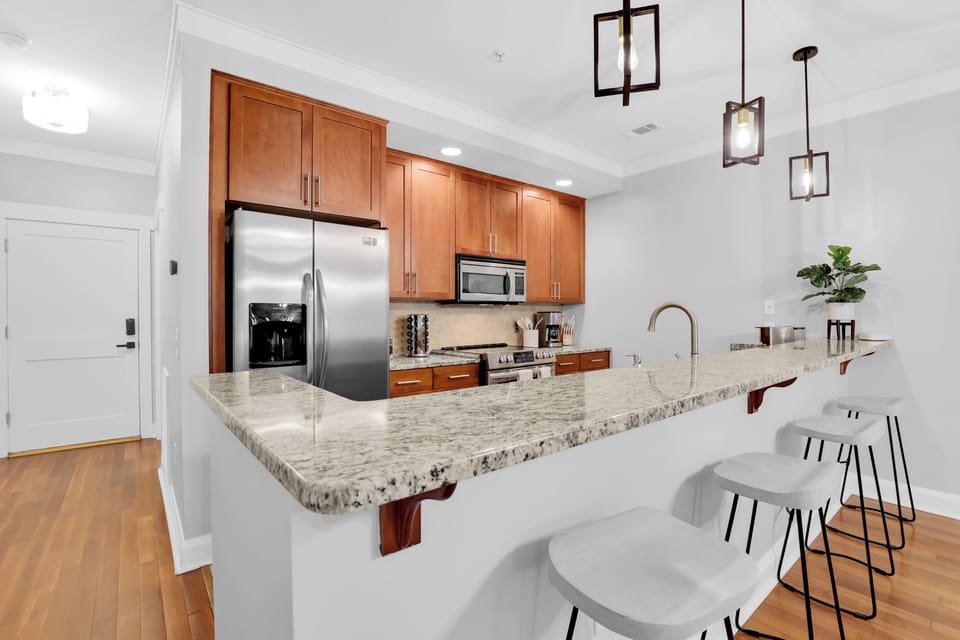Kitchen with barstool seating and modern appliances.