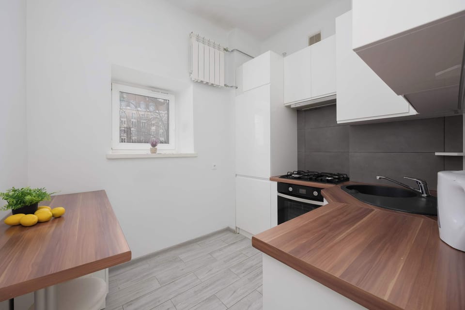 A wide-angle view of the kitchen reveals the dark countertops and white walls, creating a high-contrast look. The layout is efficient, making the most of the available square footage.