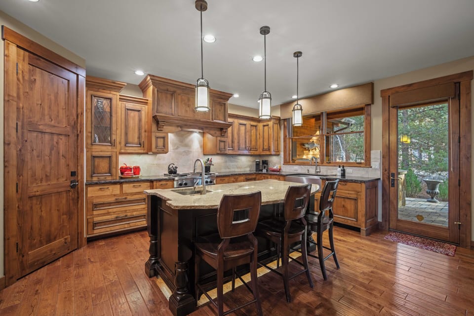 Your gourmet kitchen features rich wood cabinetry, granite countertops, and a spacious island perfect for cooking memorable meals together.