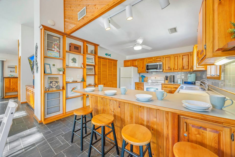 Your spacious kitchen features warm wood cabinets, modern appliances, and a breakfast bar where you can enjoy morning coffee together.