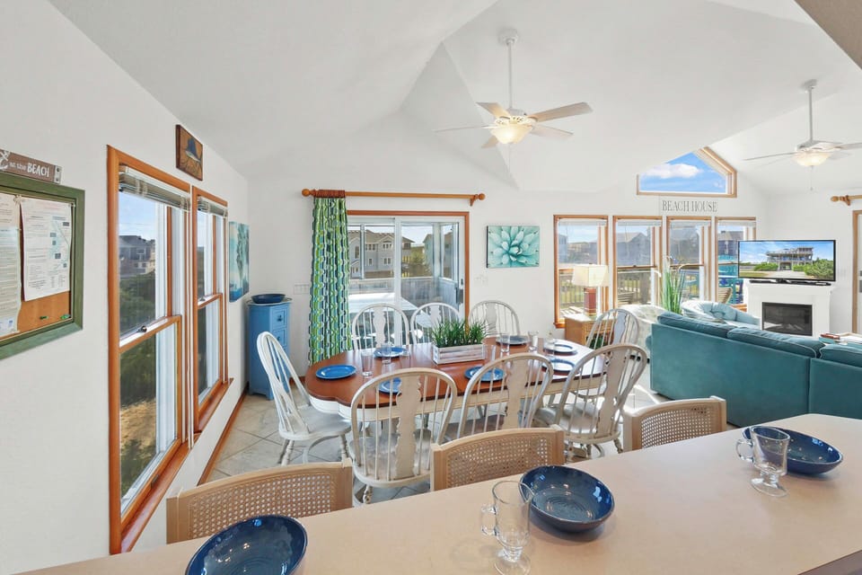 Your bright, open dining and living space features vaulted ceilings, coastal charm, and peaceful views perfect for memorable meals together.