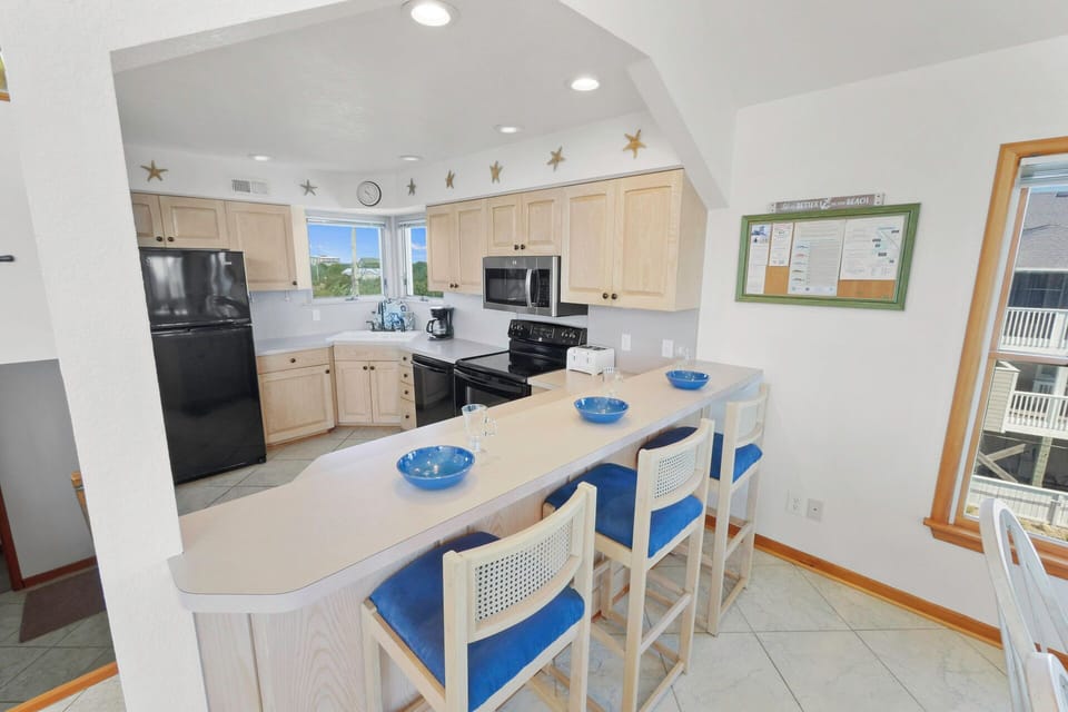 Your fully equipped kitchen features modern appliances and a breakfast bar where you can enjoy morning coffee or casual meals together.