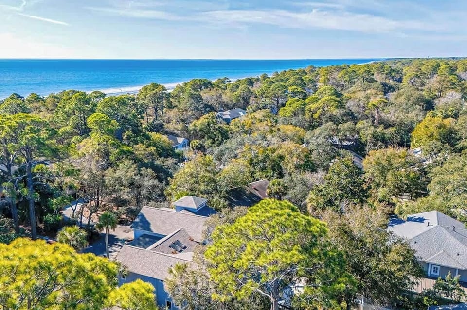 Coastal retreat nestled among mature trees, just steps from pristine beach access.