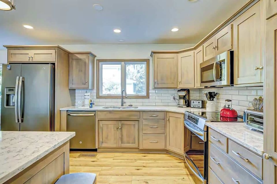 Your spacious kitchen features marble countertops, stainless steel appliances, and warm wood cabinetry—perfect for preparing meals together during your stay.