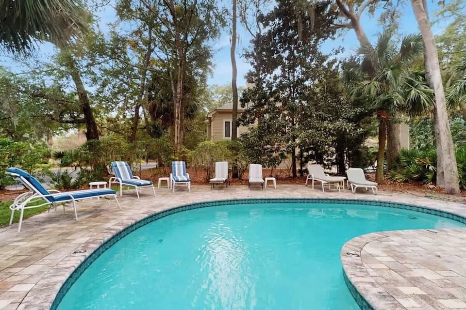 Dive into your private oasis surrounded by lush tropical palms and comfortable poolside loungers for perfect relaxation.