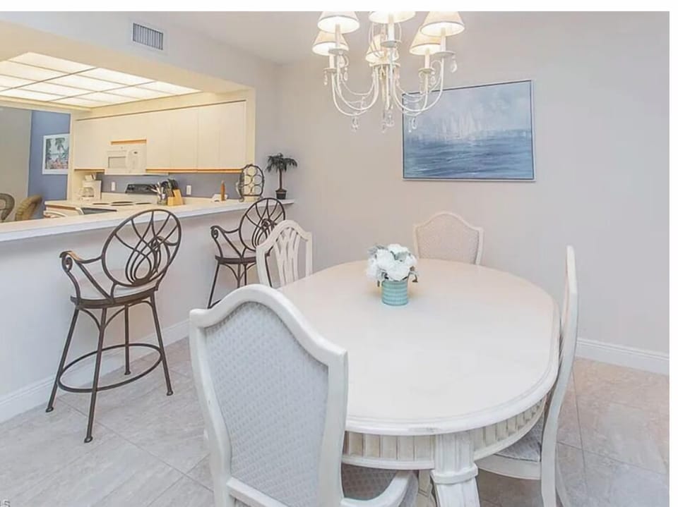 Gather around the elegant dining table under a sparkling chandelier, perfect for morning coffee or evening meals with friends and family. The open layout flows seamlessly into the kitchen, creating a welcoming space for conversation and connection.