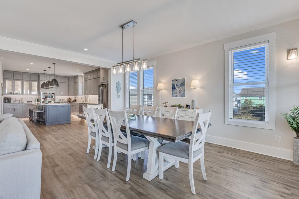 Gather around this spacious dining table where your group can share memorable meals in the open-concept living space with modern kitchen nearby.