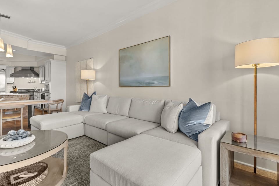 Sink into plush sectional seating with ocean-inspired blue accents. Your open-concept space flows seamlessly to a modern kitchen.