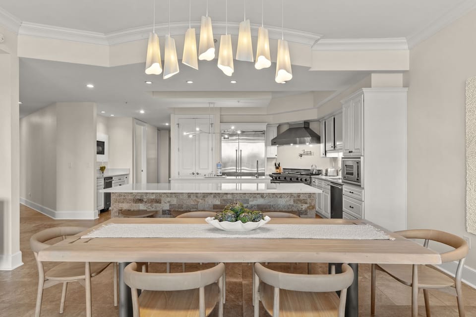 Your open-concept kitchen and dining space features elegant pendant lighting, modern appliances, and a warm wood table perfect for memorable meals.