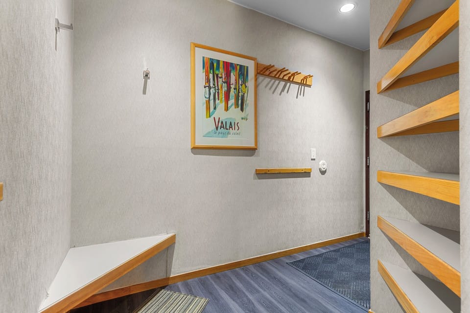 A dedicated spot for your ski gear with open wooden shelving to neatly organize everything you need for the slopes.