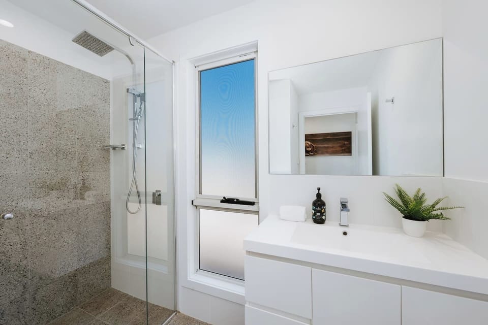 Refresh in the bathroom, where a walk-in shower, modern vanity, and complimentary toiletries make everyday routines easy.