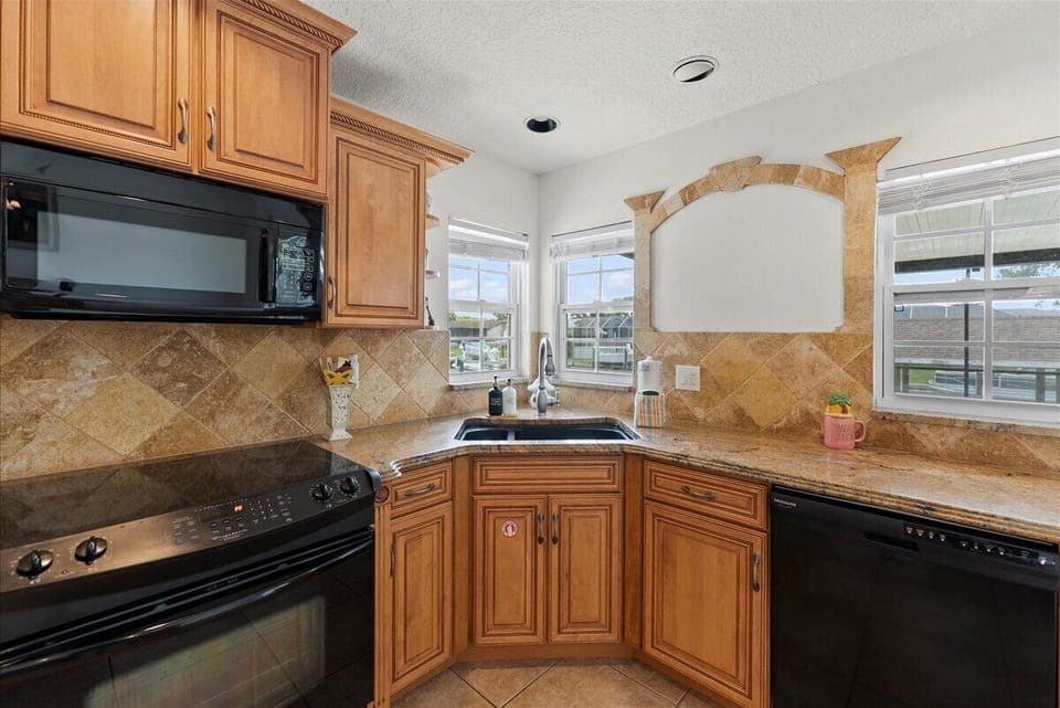 Kitchen: Culinary adventures await in this bright kitchen with granite countertops and cozy windows!

