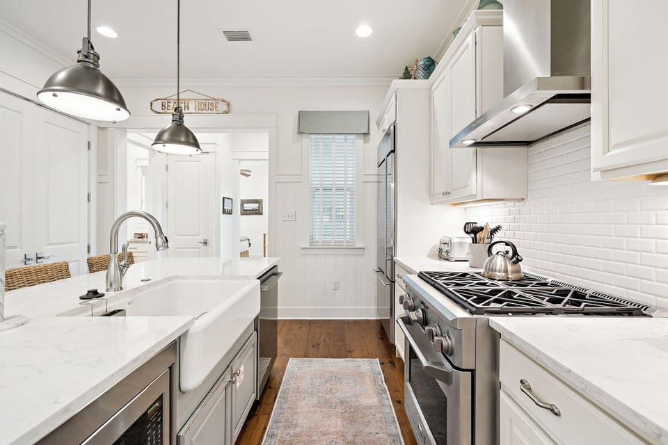 Your gourmet kitchen awaits with pristine white cabinetry, gleaming countertops, and professional-grade appliances for memorable meal preparation.