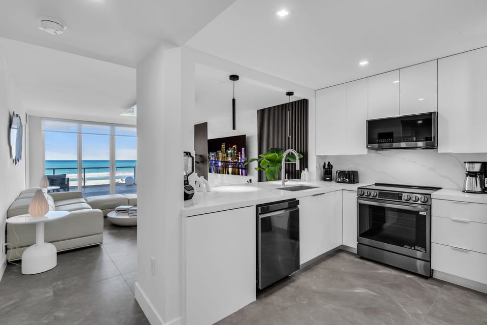Prepare gourmet meals in this sleek, ultra-modern kitchen featuring high-end stainless steel appliances and crisp white cabinetry. 