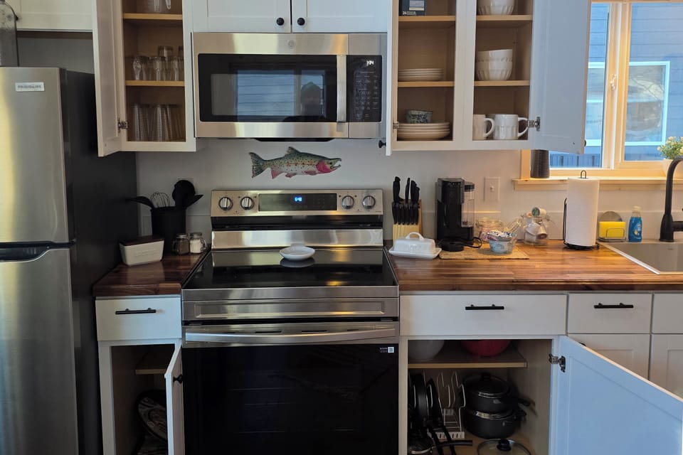 Fully stocked kitchen includes an electric range, microwave, refrigerator,  and Keurig .