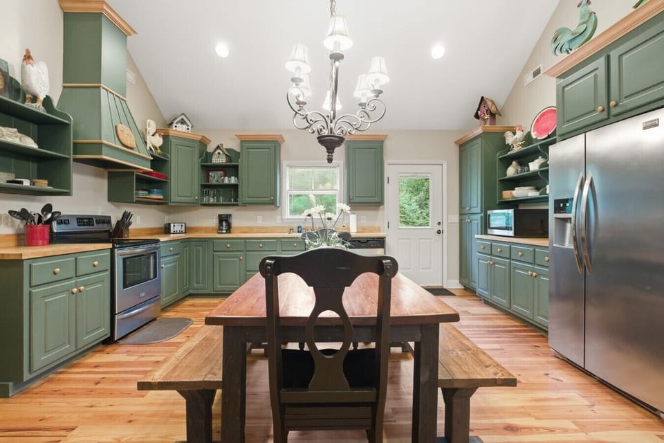 Kitchen | Green Cabinetry & Butcher Block Counters | Farmhouse Dining Table & Stainless Appliances