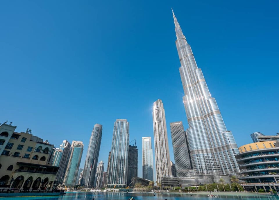 Cinematic View: Grande Signature Residences stands tall amongst the world`s most iconic towers. The perspective suggests a location that offers direct access to this vibrant outdoor area, perfect for enjoying daily strolls and evening spectacles.
