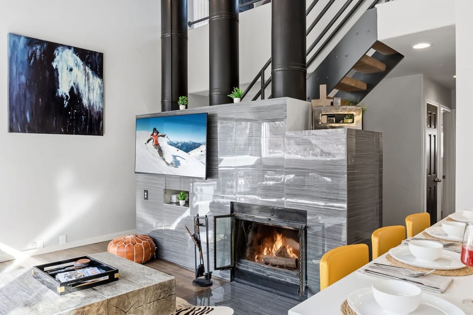 Living room: Wood-burning fireplace, 55” Smart TV, mountain views, balcony access