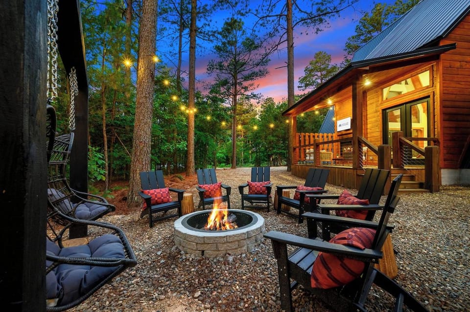 Outdoor firepit with Adirondack chairs and string lights among the pines at Broken Bow Oklahoma cabin