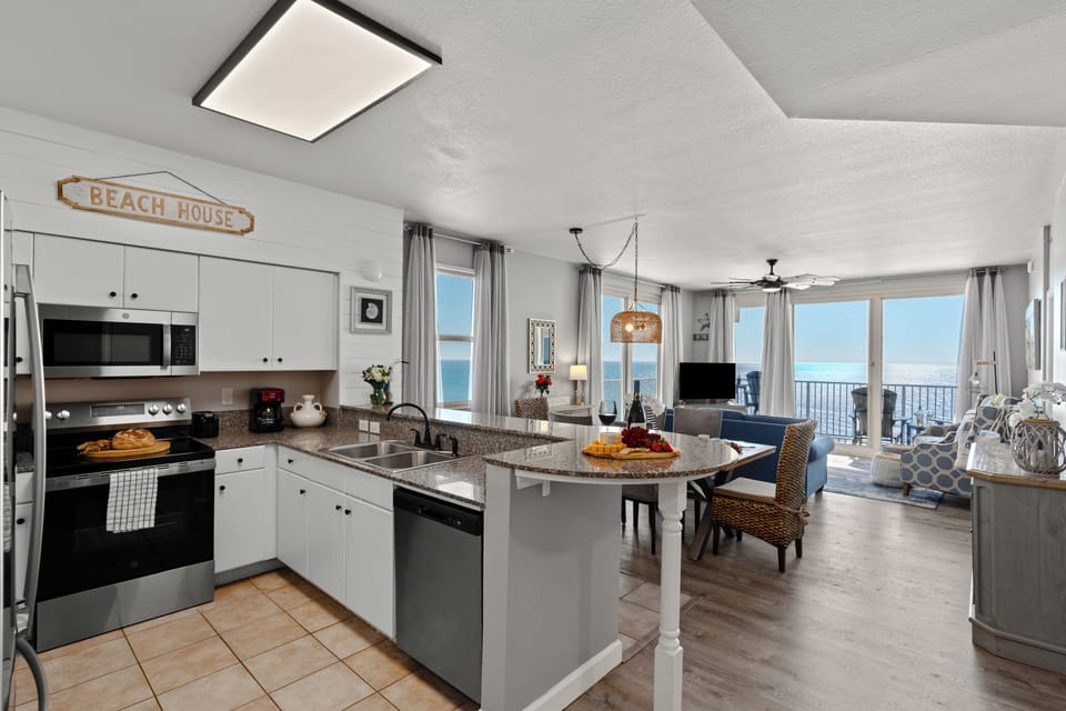 Open-concept kitchen and dining space featuring white cabinetry and a breakfast bar.