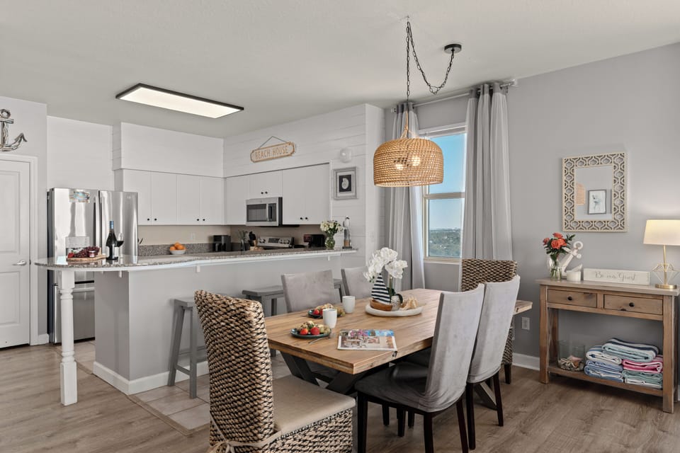 Full kitchen and dining view showing the breakfast bar and grey barstools.