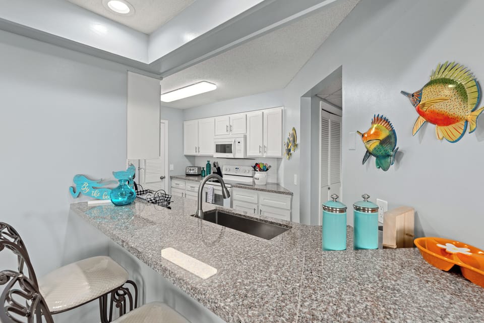 View of the deep stainless steel sink and stylish kitchen backsplash.