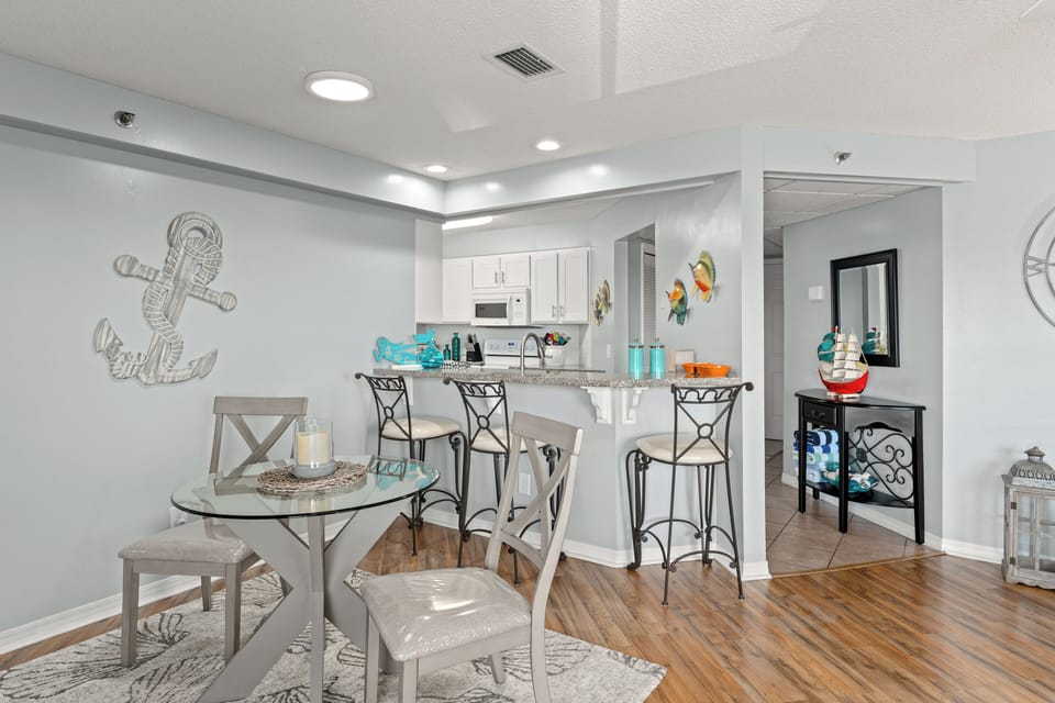 Bright kitchen featuring white cabinetry, granite countertops, and breakfast bar seating.