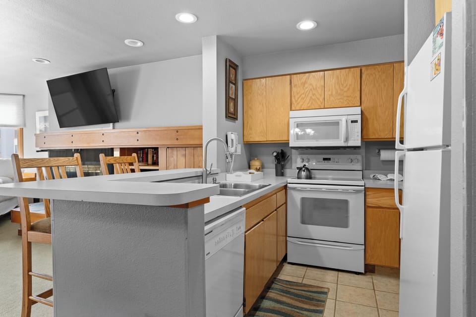 Your fully equipped kitchen awaits with modern appliances, granite counters, and cozy breakfast bar seating—perfect for preparing meals together.