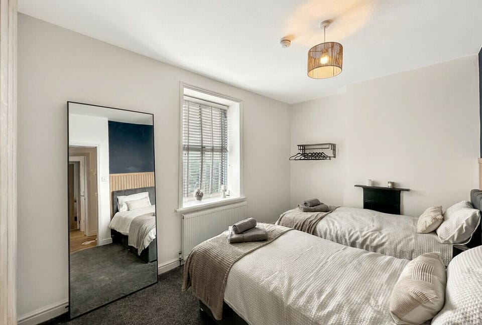 A flexible twin room with a full-length mirror and hanger rail keeps longer stays comfortable.