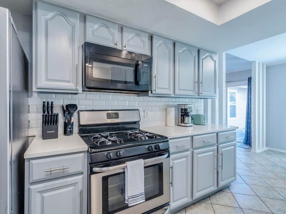 Kitchen has Dishwasher, Microwave, Refrigerator, Electric Stove, Oven, Dishware, Filter Coffee Maker. 
