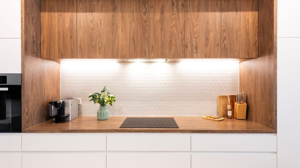 Designer kitchen detail with warm timber cabinetry and soft lighting.