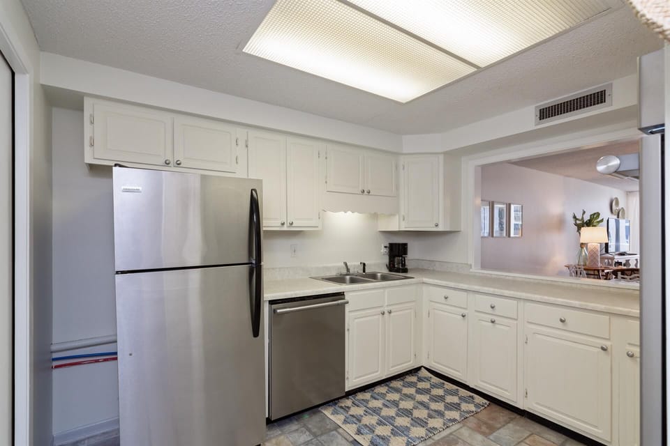 Your fully equipped kitchen features stainless steel appliances and bright white cabinetry, perfect for preparing meals during your stay.