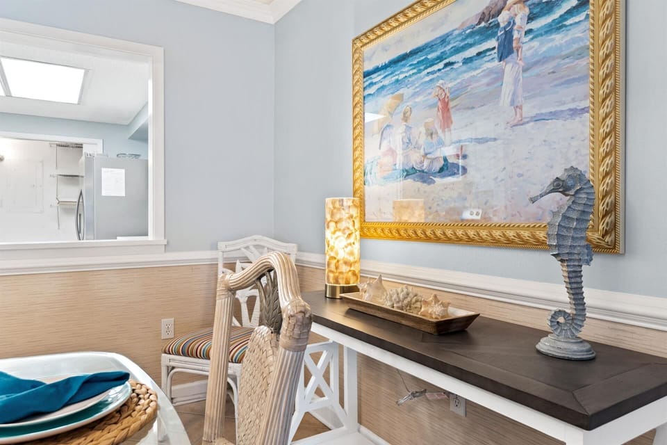 Enjoy your morning coffee at this charming coastal-themed dining nook, where ocean artwork and nautical touches create a serene beachside atmosphere.