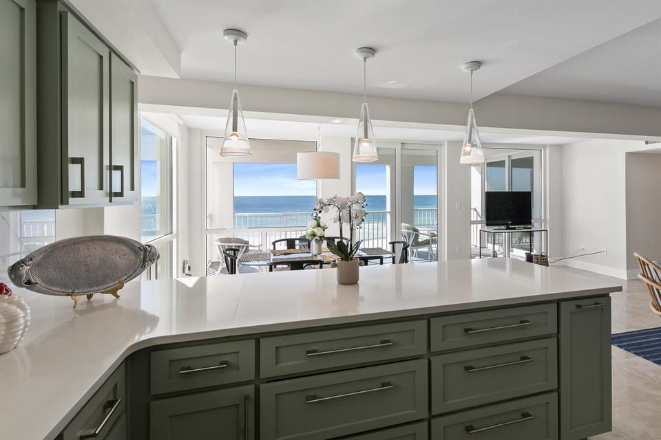 Cook with stunning ocean views from your modern kitchen, where pendant lights illuminate sleek counters and sea breezes flow through open doors.